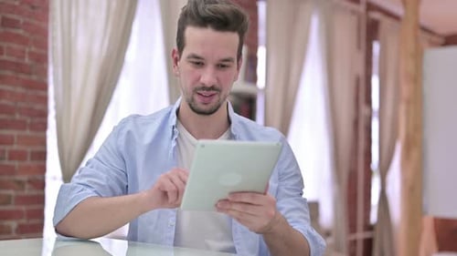 Young Man Using Tablet in Modern Office