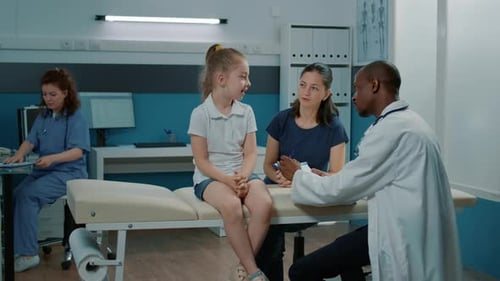 Doctor Consults with Girl and Mother in Clinic