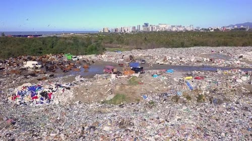 Vue par drone de la décharge de la ville sur fond de mer, de ville et de montagnes.