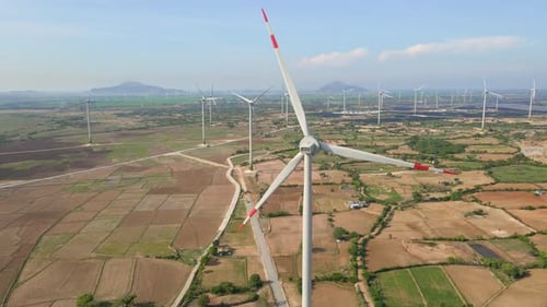 Aerial Shot of a Complex of Wind Turbines Standing on a Big Farming Field. Green Energy Concept