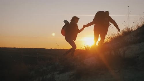 Silhouette of the Team on the Peak of Mountain. Sport and Active Life of People Man and Girl