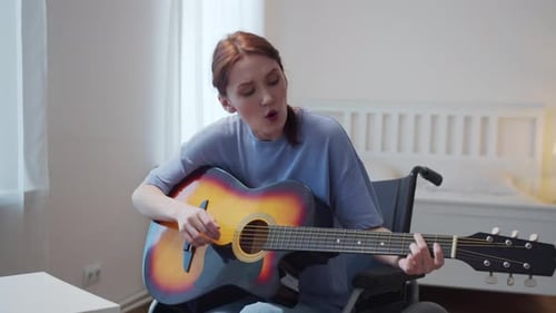 Woman in Wheelchair Plays Guitar and Sings