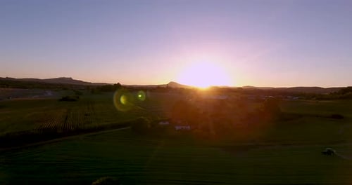 Vista aérea da pulverização de trator agrícola ao pôr do sol. 4k