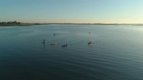Aerial Drone Footage. A Group of Tourists Are Kayaking. Beautiful Sunrise Over River