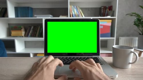 Hands Using Laptop with Green Screen Monitor