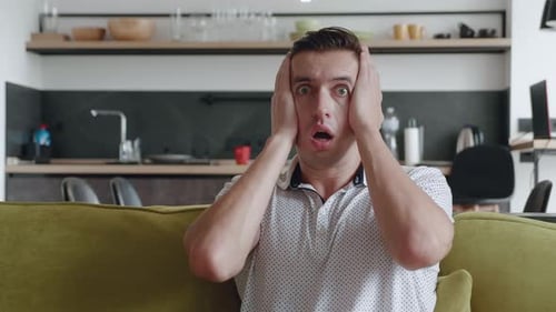 Man Reacting with Shock and Covering His Face