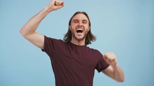 Excited Man Celebrating Success on Blue Background
