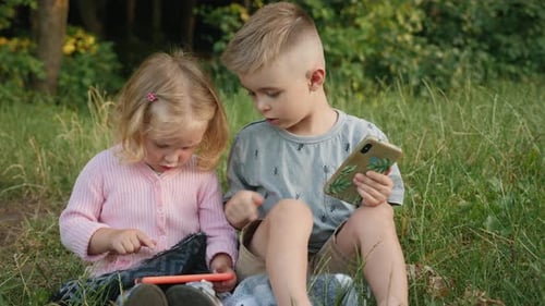 Kids Playing with Smartphones in the Park