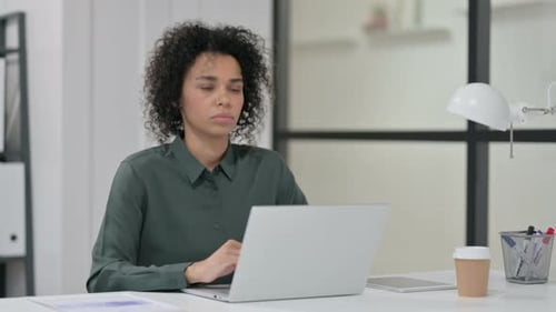 Woman Coughs While Working on Laptop in Office