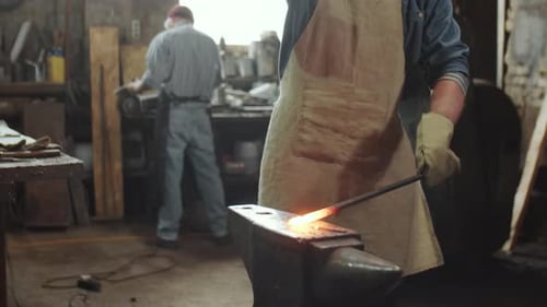 Blacksmith Hammering Hot Iron on Anvil