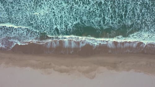 Vista aérea de las olas que chocan contra la costa