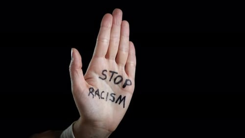 Hand with Stop Racism Message Makes a Fist