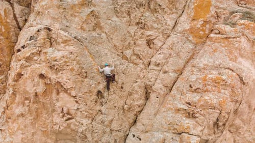 Man Athlette Climbing on the High Rock