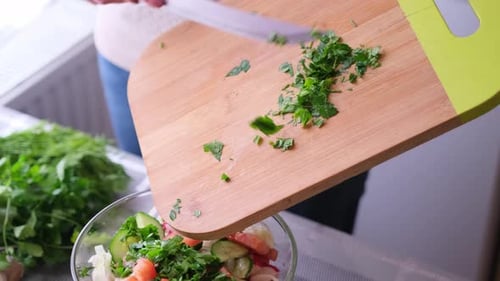 Woman Adds Parsley to Fresh Salad at Home