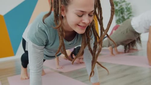 Happy Young Woman Working Out in Gym During Yoga Class with Group of People