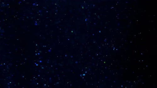 Abstract Glittering Particles on a Dark Background
