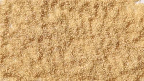 Hand Draws Heart in Brown Sugar Overhead