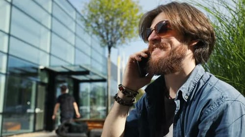 Bearded Man Talking on Cell Phone Outdoors