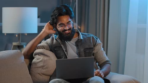 Man Chatting on Laptop at Night at Home