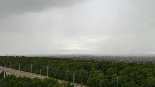Timelapse sheet rain incoming across saturated monsoon woodland highway road