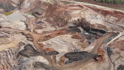 Enorme cantera industrial de minería de arcilla. Los camiones transportan arcilla y mineral de hierro cargados en la cantera