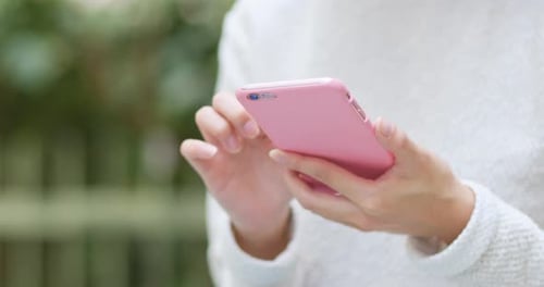 Woman Using Pink Smartphone in the Daytime