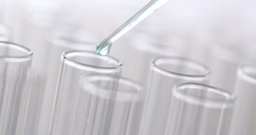 Dropping Liquid into Test Tubes in Laboratory