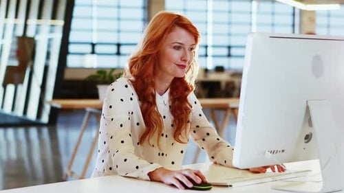 Woman working on computer at urban office desk