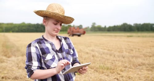 Young Woman Using Tablet in a Rural Field