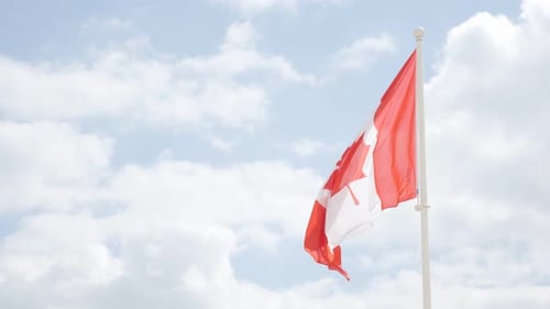 Canadian Flag Waving Gently Against Blue Sky