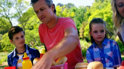 Happy family interacting with each other while having meal in park 4k