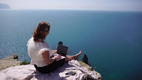 Successful Business Woman Working on Laptop By the Sea