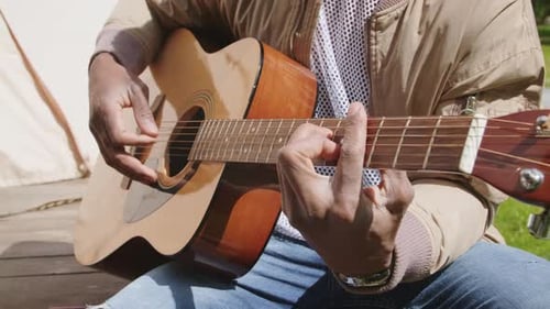 Close Up of Guitar Being Played Outdoors