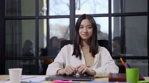 Smiling Young Adult at a Modern Office Desk