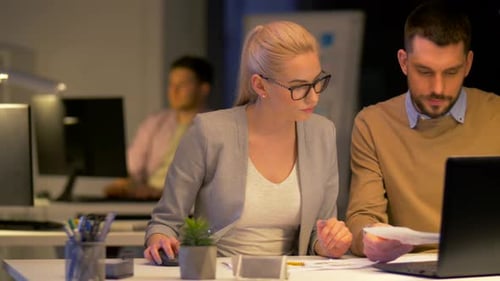 Equipe de negócios com laptop trabalhando no escritório noturno