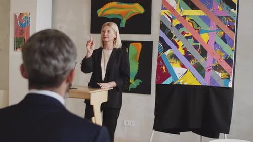 Woman Conducting Art Auction in Gallery