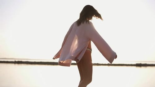 Woman Dancing on Beach at Sunset