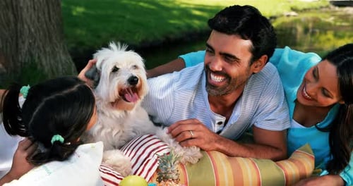Family enjoying together with their pet dog in park