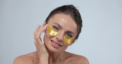 Woman Applying Eye Patches in a Beauty Treatment
