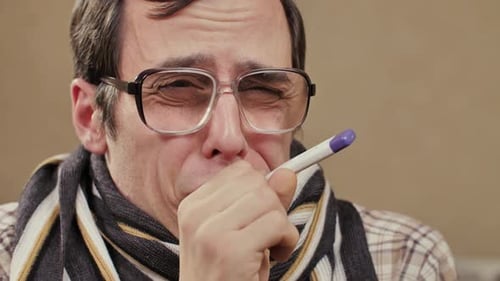 Sick Person with Thermometer Coughing Indoors