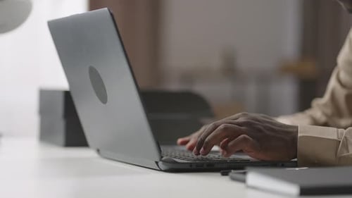 Black Man is Typing on Keyboard of Laptop in Office or Home Closeup of Hands Working and Surfing