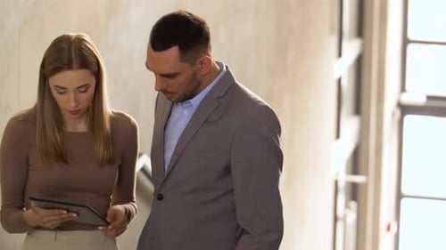 Man and Woman Working with Tablet in Office