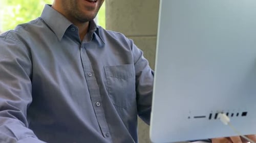 Man Smiling While Working at Computer in Office