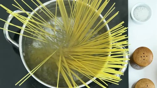 Adding Spaghetti Pasta to Boiling Water in Pot