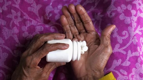 Senior Women Hand's Taking Medicine, Top View