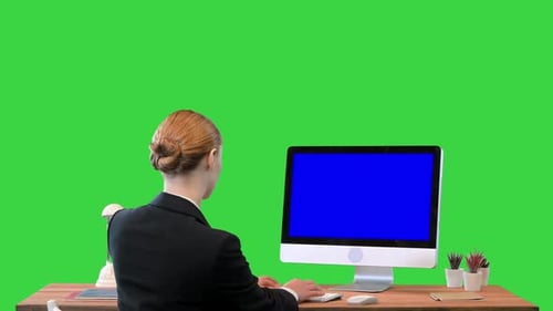 Businesswoman Working on a Computer with Blank Screen Mockup Display on a Green Screen Chroma Key