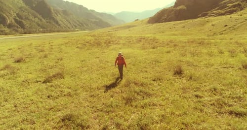 Flight Over Backpack Hiking Tourist Walking Across Green Mountain Field