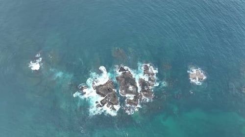 Waves Crash Against Rocks in the Ocean