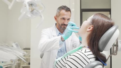 Dentist Examines Woman Patient in Dental Office