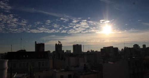 Time lapse of sun setting over city skyline